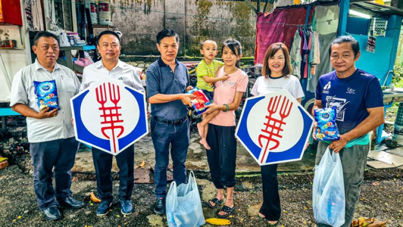 在晋汉连省华总副会长甲必丹陈国璋(左二)丶华青团团长甲必丹陈德明(左一)的见证下，华总福利组主任彭国良(左三)移交奶粉及一千一百令吉医药费给黄余伟斌小弟弟之母亲黄仪凤。右一为副福利主任李国豪及华总妇女组主任张慧娇。