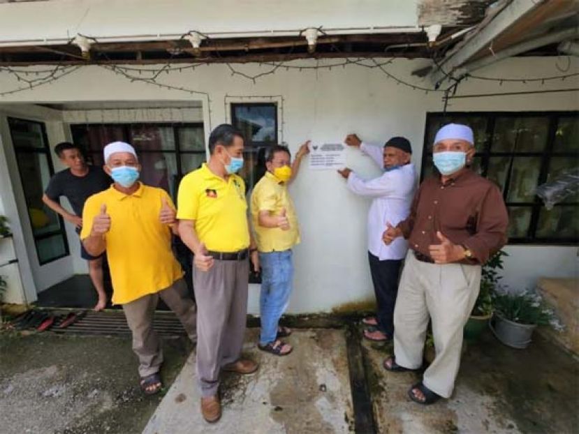  拿督斯里沈桂贤(右三)巡视其中一所完成维修的房子。