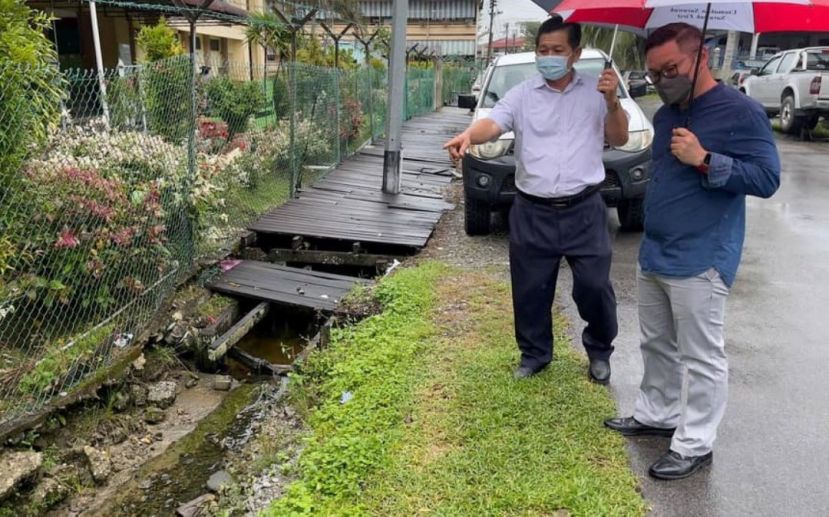 砂助理部长程明智（右）巡视市政第四校旁需改善的陈旧行人道及沟渠问题。