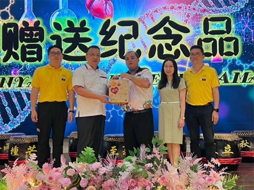 一小校长郑再恒（中）赠送纪念品予古晋中华小学校董会主席拿督蔡文铎时影。