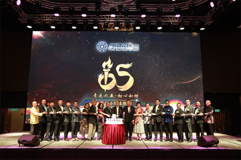 青运在65周年晚宴上进行切蛋糕仪式，并推介每年7月1日定为"青运日"（YMM Day）；左10为欧阳玉靖、颜丕永及刘官金。