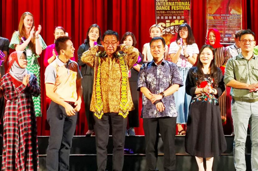 拿督阿都卡林戴上达雅串珠披肩。前排左二是诗巫国际舞蹈节艺术总监陈永光。右一至三是诗巫区国会议员林财耀，南兰区国会议员刘强燕，砂旅游、艺术、文化、青年及体育部常务秘书许赞麒。