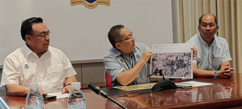 古晋南市市长拿督黄鸿圣（中）展示通往民众会堂古晋美食节的路线图，左一为副市长希尔米（左）、古晋南市市政局古晋节庆典筹委会主席莫壮平（右）。