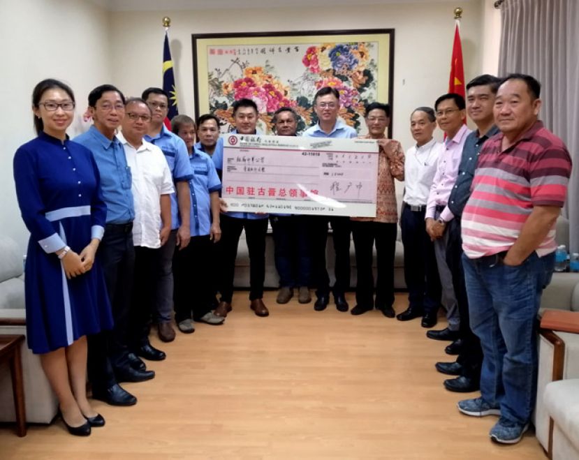 在砂首长署政治秘书陈开（右六）见证下，中国驻古晋总领事程广中（右五）移交1万5000令吉模型支票予短廊中华公学校董会主席李思兴（左七），左起;为中国驻古晋领事邵笑、短廊中华公学建校委员会顾问李仁赵、顾问官有盛、秘书刘佑隆、委员刘国强、委员李永良；财政刘永坚、顾问许礼美、顾问刘天亮、程洪领事、及委员温多尼（右七）。