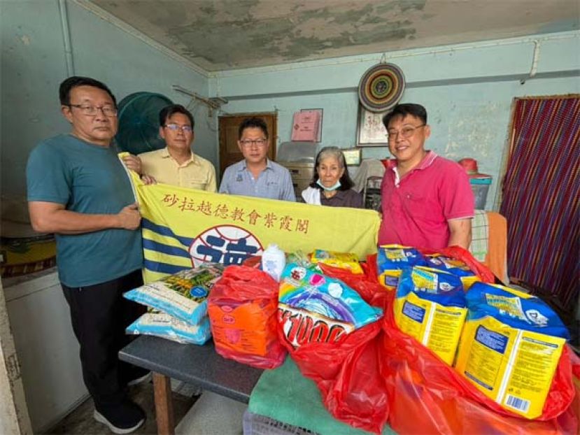 砂拉越德教会紫霞阁福利主任陈梦仁（右1）移交救济品于一名行动不便者家属（右2），表达紫霞阁对弱势群体的关怀与支持。随同者包括紫霞阁副秘书郑志国市议员（中）、甲必丹郭贵华（左2）及甲必丹黄文益（左1）。