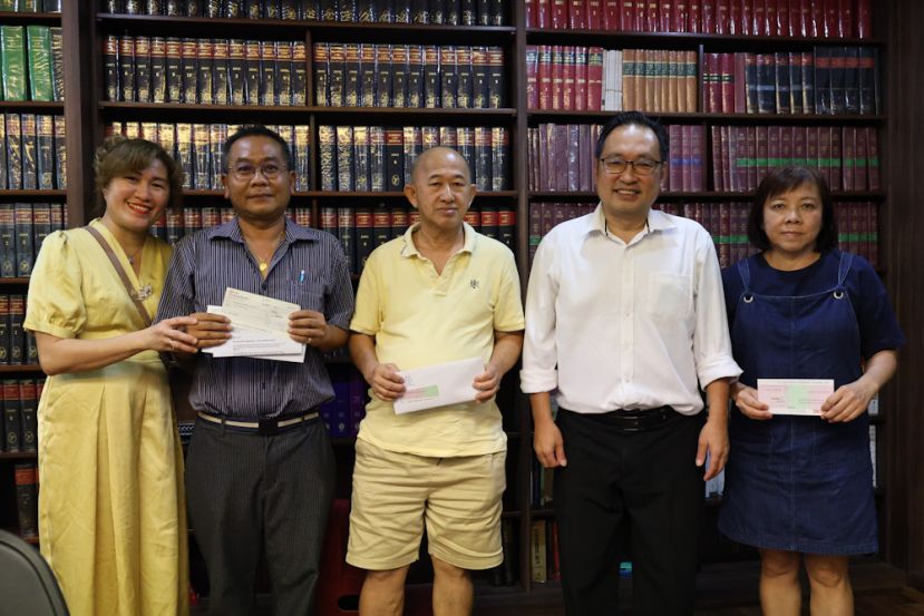 张健仁移交助学金支票给前来代领孩子的李氏基金助学金支票后合影。