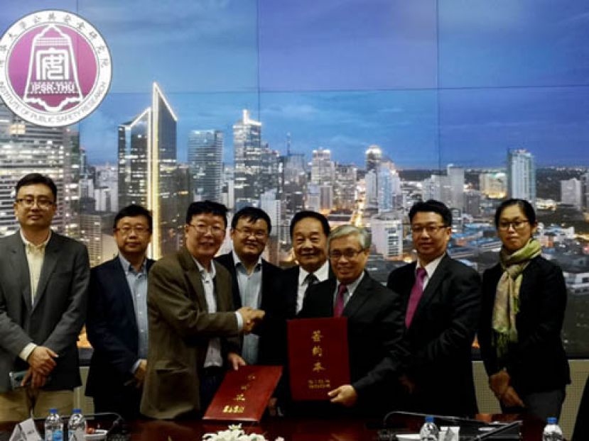 在黄順舸及陈建国(右四及五)见证下，砂科技大学校长拿督凯鲁丁(右三)与清华大学公共安全研究院副院长张辉交换合作备忘录签约本；右起为;砂科大国际外办主任黄宝媚博士及基础课程学院院长黄声心博士。