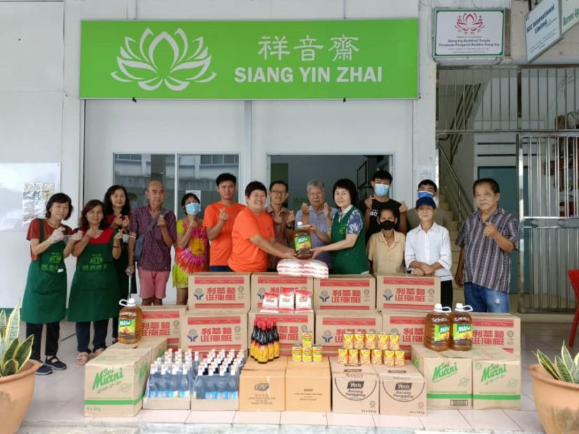 呂晗韻（左7）代表38爱心慈善基金会移交食品物资予祥音斋主席黄松熙（左9起）及理事吴普合；左8为见证者薛华东。