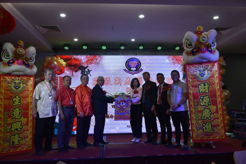 晋汉连省庄严宗亲会会长莊永隆（左四）和筹委会主席莊映资（右四）在众人陪同下，从瑞狮接过采青；左起为马来西亚庄严宗亲总会总秘书莊兴发、槟城莊严宗亲会顾问拿督莊文财、马来西亚庄严宗亲总会总会长拿督莊秀春，右起为古晋区国会议员俞利文代表江峰年、峇都吉当区州议员兼巴达旺市议会主席罗克强代表庄育华、晋汉连省庄严宗亲会永久名誉执行顾问莊义德。