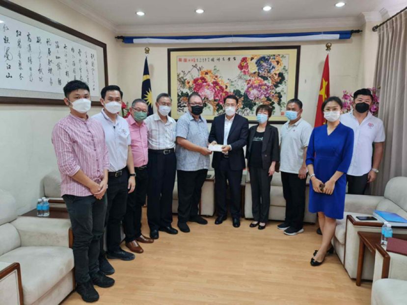 中国驻古晋总领事邢伟平（右五）移交拨款予古晋中中校友会会长拿督黄国辉（左五），左一起为古  晋中友会副财政张职程、副会长兼青年团团长陈明、秘书长田荣喜、副会长张光福、右一起为副秘书长陈伟政、邵笑领事、教育主任吴泽源教育主任、中国驻古晋副总领事宋长虹。