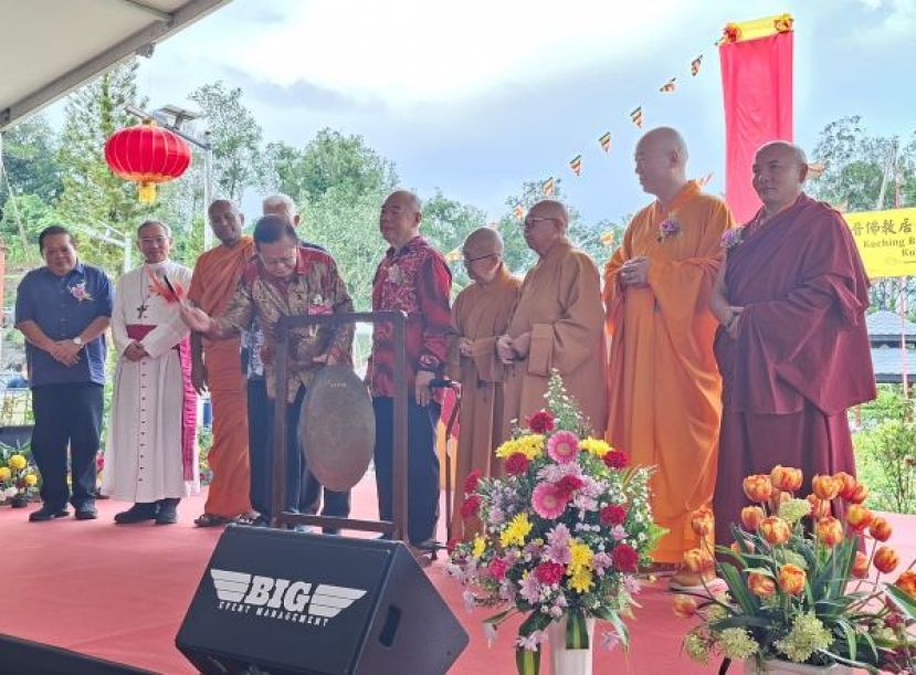 砂交通部部长拿督斯里李景胜（前左）在嘉宾们的陪同下，为古晋佛教新村主持开幕仪式，并鸣锣庆祝新村正式启用，象征佛教事业发展迈入新里程碑。