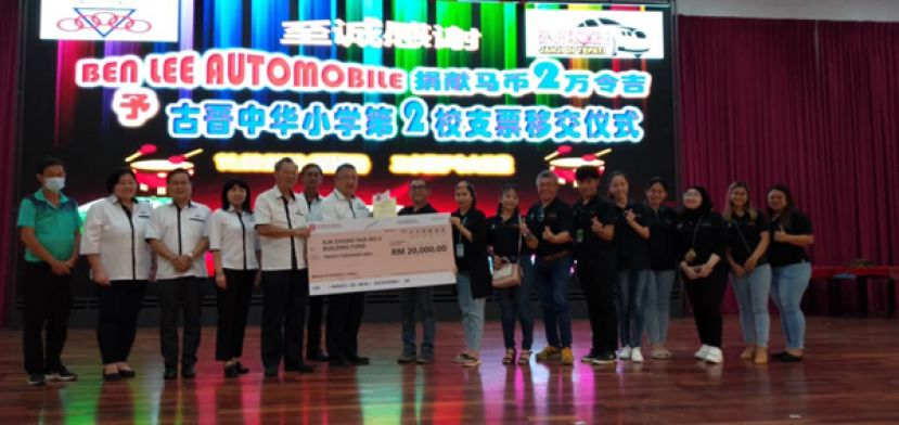 在古晋中华小学校董会主席拿督蔡文铎律师（左七）的见证下，BEN LEE AUTOMOBILE东主李惠日（左把）移交2万令吉捐款给二小副主席张光福（左五）。左起为二小副校长房顺芳、二小视察郑姝萍、校董会副财政周天龙、校董会副财政罗绍凤及二小视察唐才茗。