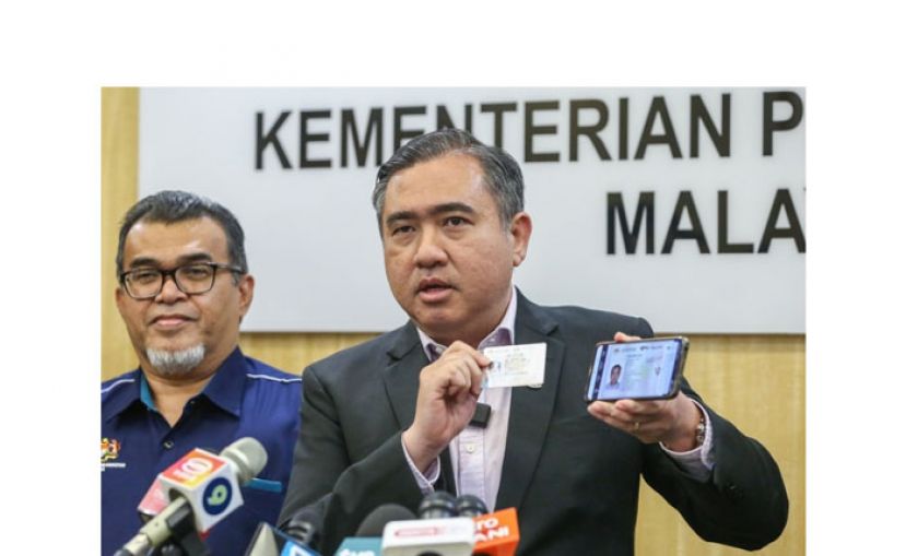 陆兆福(右)展示其电子驾照，左为副部长哈斯比。