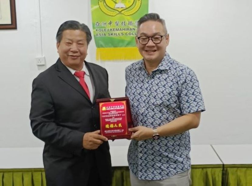 亚洲中医技职学院院长江宗兴赠纪念品予拿督程明智副部长。