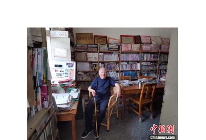 庞汝勋坐在他的民间图书室内。