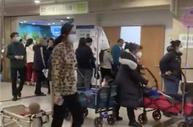 山东济南的医院患者众多，不少家长出动露营推车当移动病床。