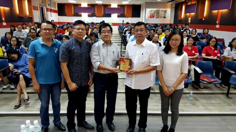  砂拉越星座诗社主席黄泽荣（中）赠送纪念品给砂华总会长拿督黄良杰（右二）。左起为砂星座诗社秘书蔡集淞、砂教育厅督学刘宥強及新纪元学院中国语言文学系主任伍燕翎博士。