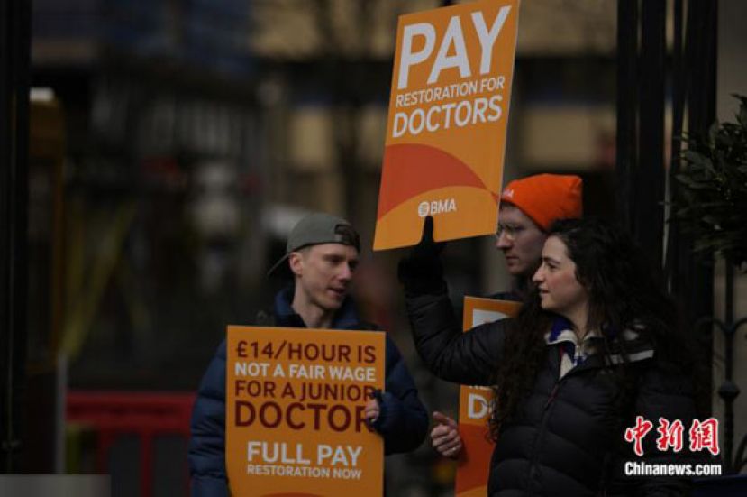 2023年3月14日，英国的初级医生在伦敦圣玛丽医院外举着标牌举行罢工活动。