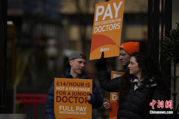 2023年3月14日，英国的初级医生在伦敦圣玛丽医院外举着标牌举行罢工活动。
