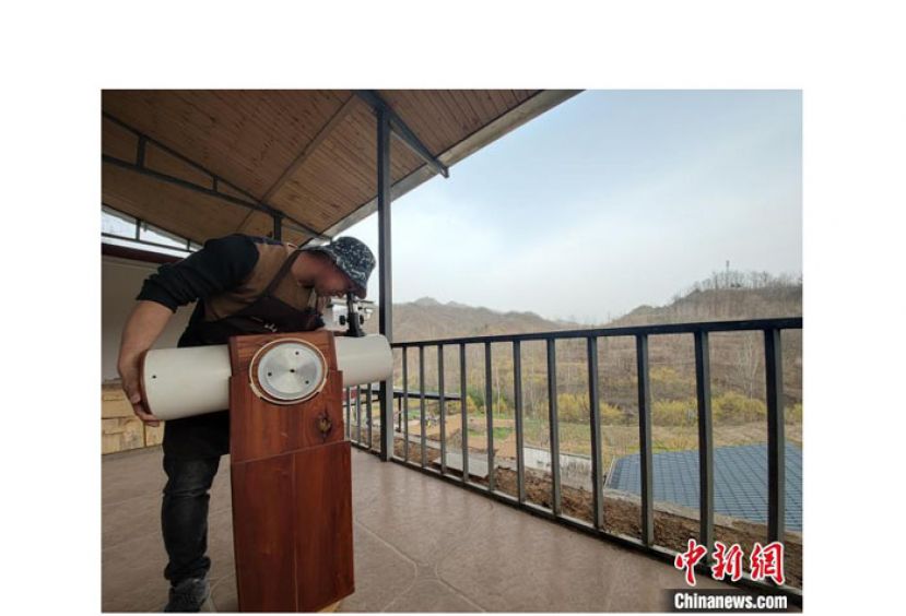 王耀斌演示自制的反射望远镜。