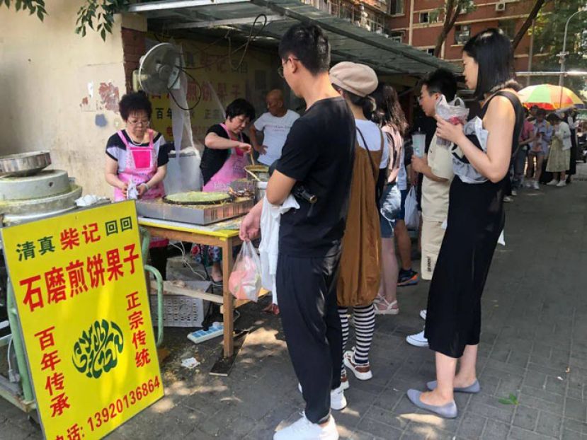 煎饼果子摊位前排起的长队。