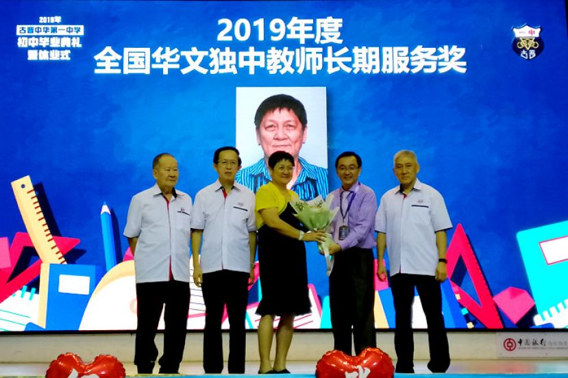 在古晋中华第一中学校长叶宗元（右二）颁发2019年度全国华文独中教师长期服务奖予陈云湄老师（左三），左一为;一中视察钟名宝、中中校董会副主席郑佑上(左二)、一中监学何健赞（右一）。
