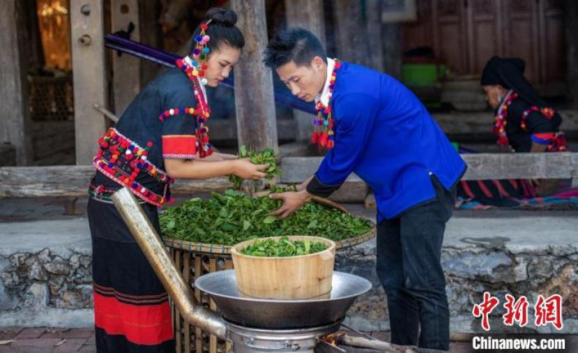 德昂族制茶人将新鲜茶叶蒸熟。