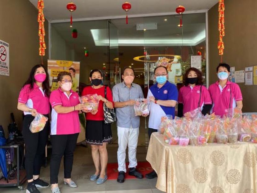 古晋巴达旺福州公会主席甲必丹拿督刘思乐（右3）和妇女组主任朱缮霖（左2）分别移交拗九粥给秘书长林唐锦及夫人王寿英。左起为古晋巴达旺福州公会妇女组副体育黄丽美、妇女组公关廖伟爱及副公关杨美爱。