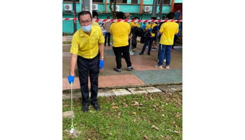 巴达旺市议员叶耀星以身作则，拾起地上垃圾。