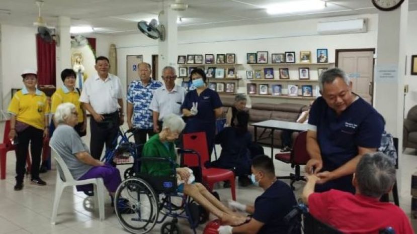 砂同心善堂主席黄国远（左4）与正康爱心中医团队总监钟其每等人在平安之家施医赠药现场。