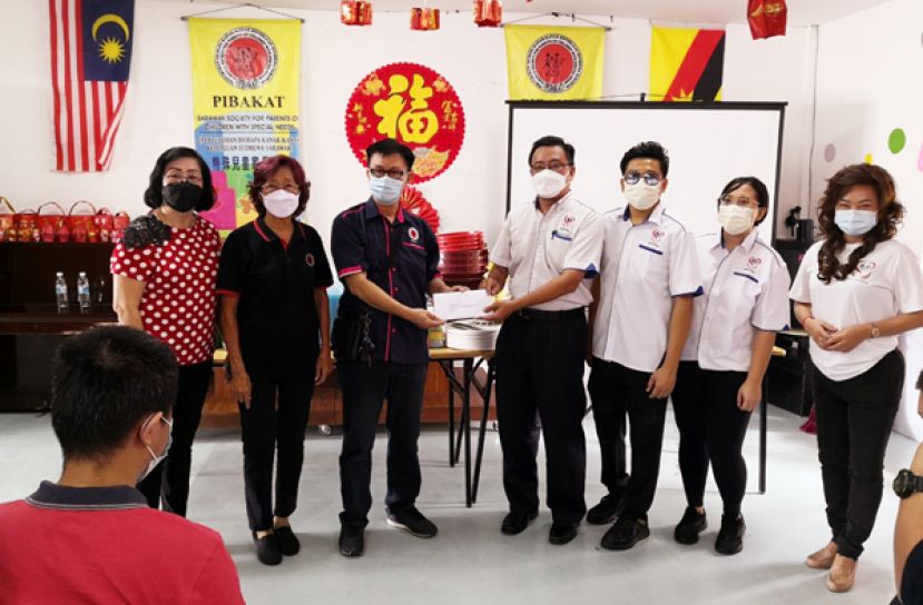 马来西亚善心组织古晋理事田志和（右四）移交捐款予砂拉越特殊儿童协会财政张均祥（左三）。左一与左二为该协会执行秘书郭燕  萍及委员邓新香。