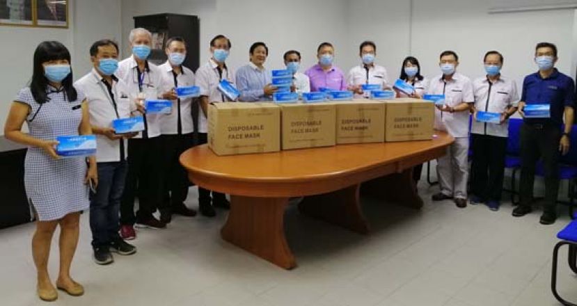 古晋中华小学校董会主席拿督王长福（左六）移交口罩予一小校长李美发（右七），左起为一小副校长沈莉俐、四小监学吴孟敦、校董会副秘书长林光钟、二小副主席张光福、一小副主席梁柏就；右起为一小副校长方秉发、四小副主席黄云华、六小副主席蓝里安、副财政罗绍凤、秘书长田松茂及署理主席蔡文铎。