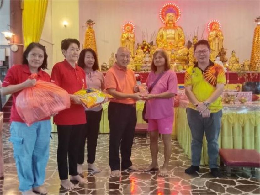 在该会地藏王慈善会主席房秀芳（左三）及理事郑志国市议员（右一）的陪同下，主席拿督斯里郑正金（左四）颁发红包及米粮于其中一户家庭时影。