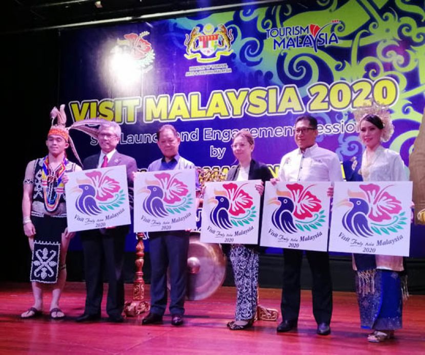 旅游、艺术及文化部长拿督莫哈末丁（左三）与展示2020大马旅游年标志。