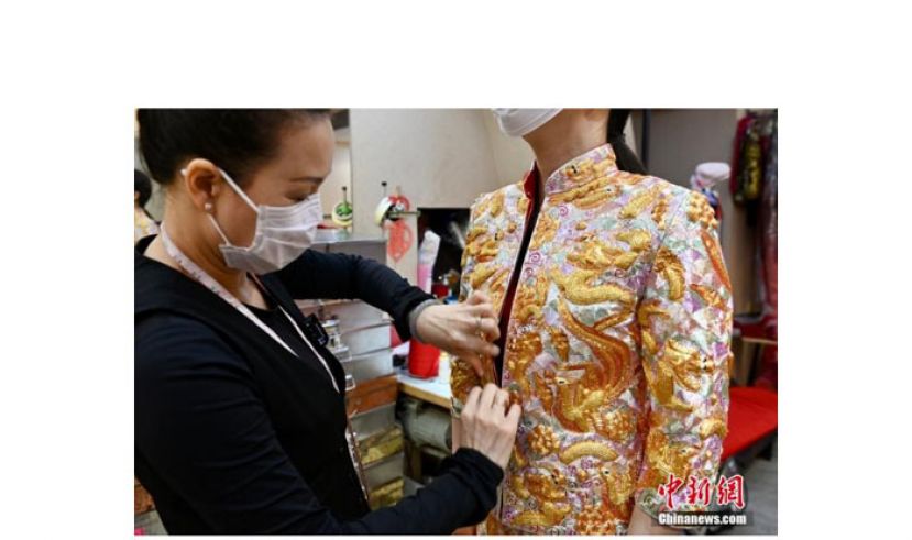 师傅为女士整理裙褂。