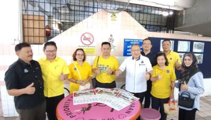 古晋南市市长拿督黄鸿圣（右三）在肯雅兰小贩中心进行实地巡视及移交仪式和市议员等合影。