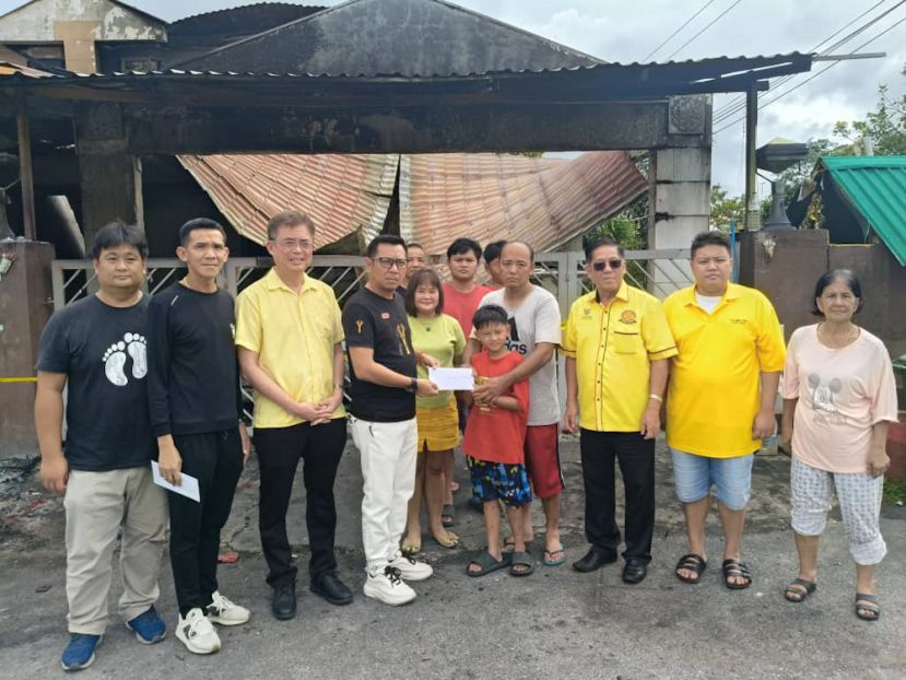 社团闻人蔡传伟(左四) 移交援助金给予火灾灾民。 左二为救援团队团员蔡毅豪；左三为巴达旺市议会主席陈开；右二为龚财源及右三为天猛公陈如飞。