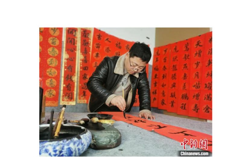 惠施祥在写春联。