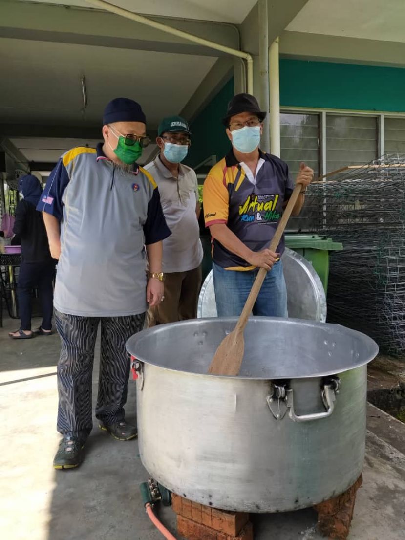 州首席童军总监再努丁正在搅拌稀饭。