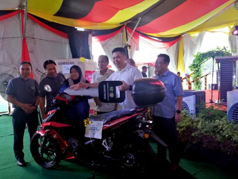 拿督连达立夫（右四）见证下，主办单位负责人移交电单车锁匙予幸运儿。
