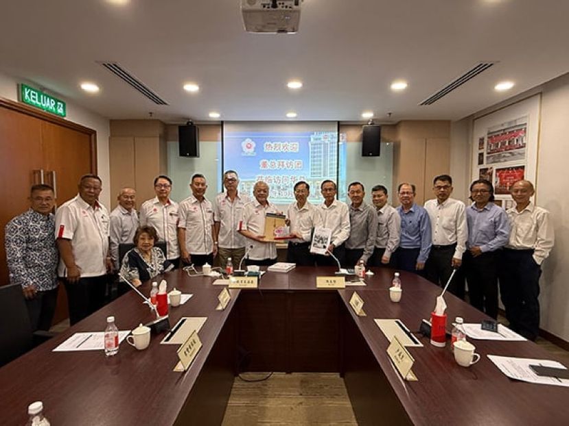 吴添泉（左8）赠送纪念品予陈友信（左9）。左起为徐来兴、胡健强、涂兴全、陈达真、杨有为、黄保俊和郑炳丰；右起为林泽民、陈云枫、萧福才、萧汉昌、黄再兴、卢成良及李添霖。