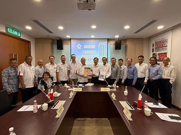 吴添泉（左8）赠送纪念品予陈友信（左9）。左起为徐来兴、胡健强、涂兴全、陈达真、杨有为、黄保俊和郑炳丰；右起为林泽民、陈云枫、萧福才、萧汉昌、黄再兴、卢成良及李添霖。