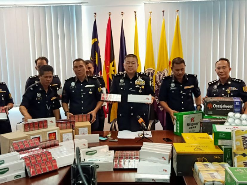 拿督许国振向媒体展示起获的烟酒。