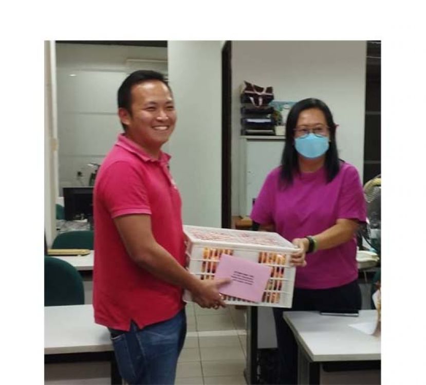 砂行动党主席张健仁特别助理江峰年（左）移交礼品，由国际时报采访主任林莉琳接收。