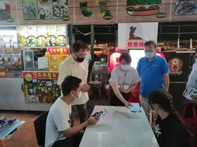 人民公正党砂州妇女组秘书黄培慧（左三）与该党古晋区部主席黄锦河律师（左二）以及其他党员领袖的陪同下访问古晋各饮食中心分发口罩予群众。