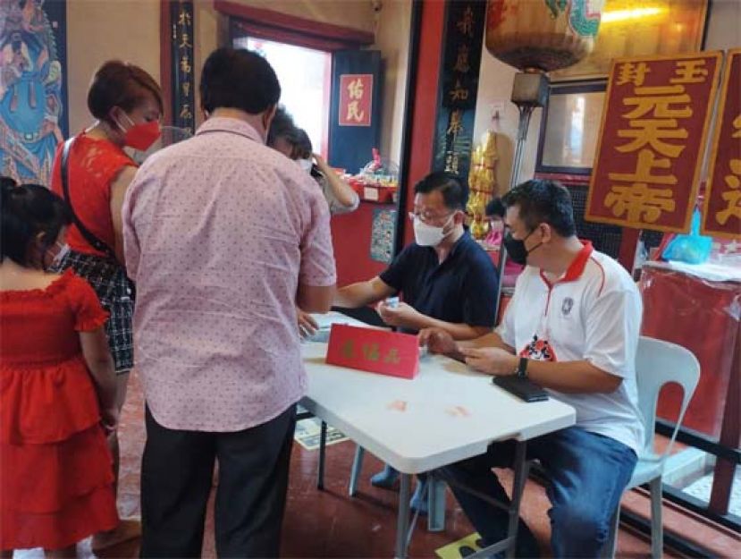善信在进行还福品时摄。右起为潮州公会会长周文盛以及公关主任郭景盛。