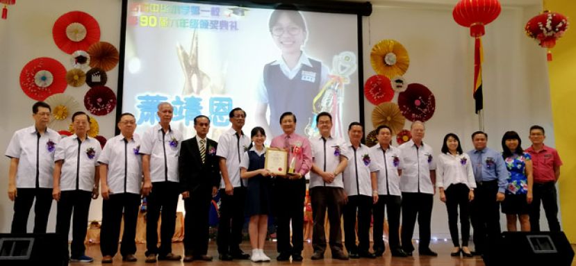 古晋中华小学校董会主席拿督王长福（右九）颁发一小最佳模范生奖给萧靖恩（左七），左起;为古晋中华小学校董会四小视察沈楚鹏、四小副主席黄云华、副秘书长林瑞钊、副秘书长林光钟、一小校长李美发及一小副主席梁柏就；右起;为一小副校长方秉发、一小副校长沈莉俐、一小副校长萧家宝、校董会副财政罗绍凤、查账甲必丹田汉河、六小副主席蓝里安、一小监学李河龙及秘书长田松茂。