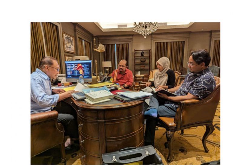 首相安华(左)回到首相署，与官员讨论工作。