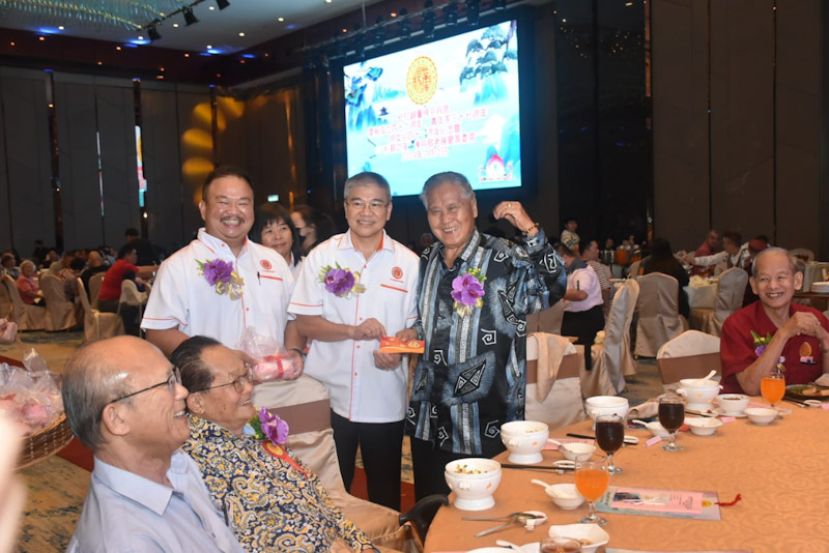 会长杨娘坤（中）与筹委会主席杨子然（左）颁发敬老红包与礼品予拿督杨昆贤（右）。