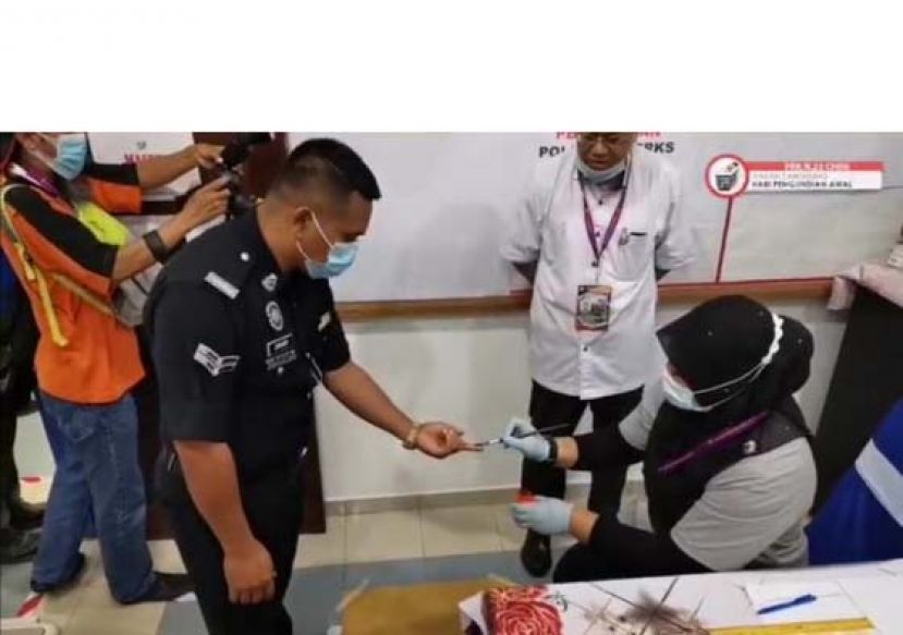 选委会工作人员的提前投票的警员手上点墨。